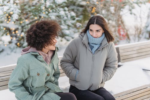 坐在灰色外套的女人旁边的灰色外套的女人 · 免费素材图片