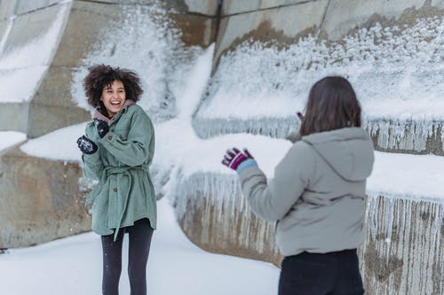 站在大雪覆盖地面上的绿色外套的女人 · 免费素材图片