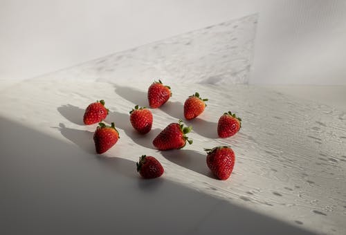 在白色纺织品上的红色草莓 · 免费素材图片