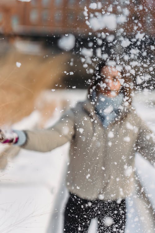 站在雪地上的棕色外套的人 · 免费素材图片