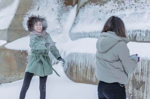穿着绿色站在雪地上的女人 · 免费素材图片