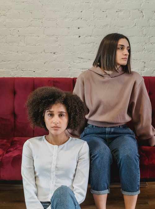 坐在棕色毛衣的女人旁边的白色长袖衬衫的女人 · 免费素材图片