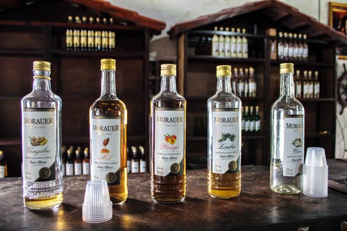 棕色木制的桌子上的透明玻璃瓶 · 免费素材图片