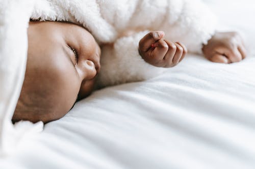 婴儿躺在白色的纺织品 · 免费素材图片
