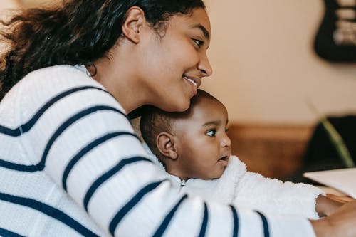 白色和黑色的条纹长袖衬衫携带婴儿的女人 · 免费素材图片