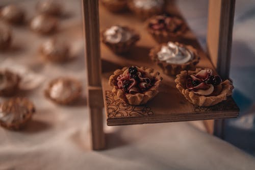 棕色和白色纸杯蛋糕上棕色木制托盘 · 免费素材图片