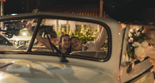 男人和女人在车前微笑 · 免费素材图片
