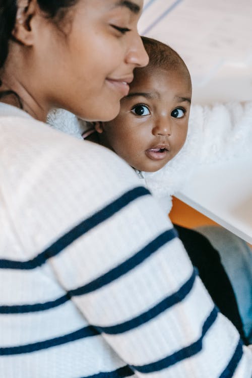 躺在床上的白色和蓝色条纹衬衫的男孩 · 免费素材图片