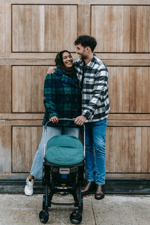 黑色和白色格子衬衫和棕色的裤子，背着黑色和蓝色行李的男人 · 免费素材图片