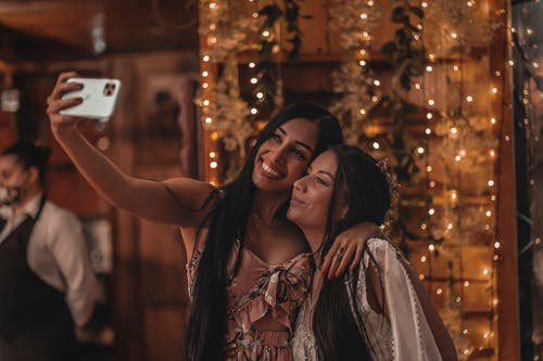 棕色和白色的花裙子，握住她的头发的女人 · 免费素材图片