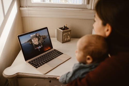 灰色连帽衫的男孩看着macbook Pro · 免费素材图片