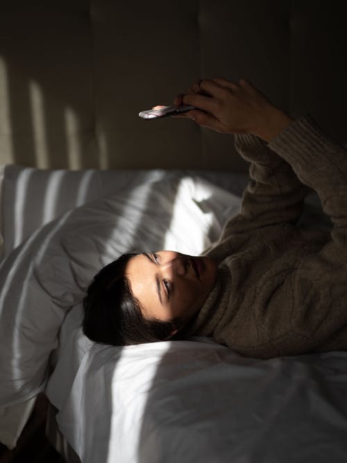 躺在床上的灰色毛衣的女人 · 免费素材图片