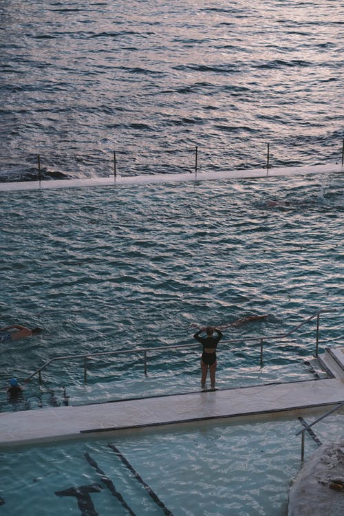 黑色衬衫站在码头上的人 · 免费素材图片