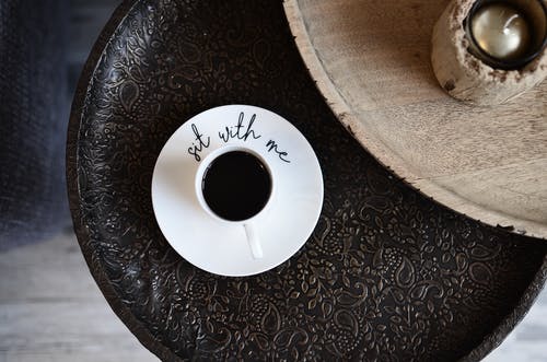 棕色木制的桌子上的白色圆形塑料 · 免费素材图片