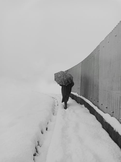 黑夹克的人在积雪的通路上行走 · 免费素材图片