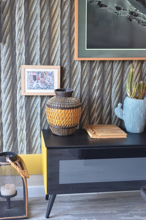 棕色和黑色陶瓷花瓶棕色木制的桌子上 · 免费素材图片