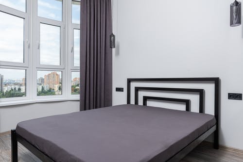 紫色床单附近棕色木制床架 · 免费素材图片