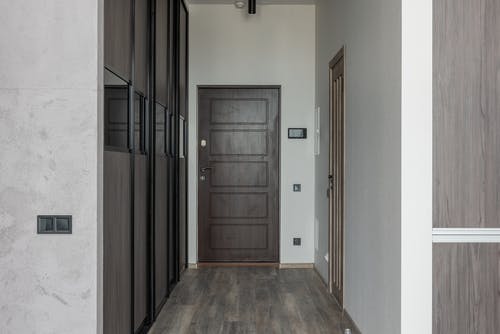 白墙附近的棕色木质门 · 免费素材图片