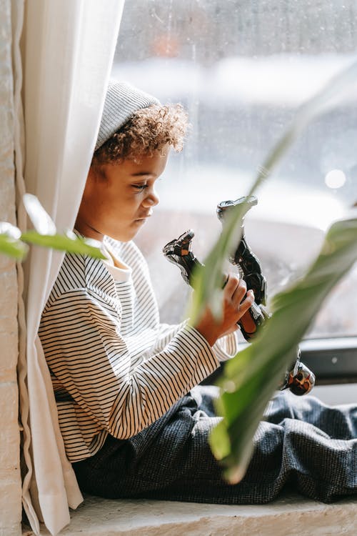 拿着绿色的植物的白色和黑色条纹长袖衬衫的女人 · 免费素材图片