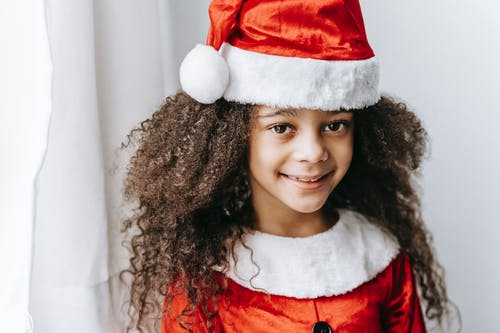 红色和白色圣诞老人帽子的女孩 · 免费素材图片