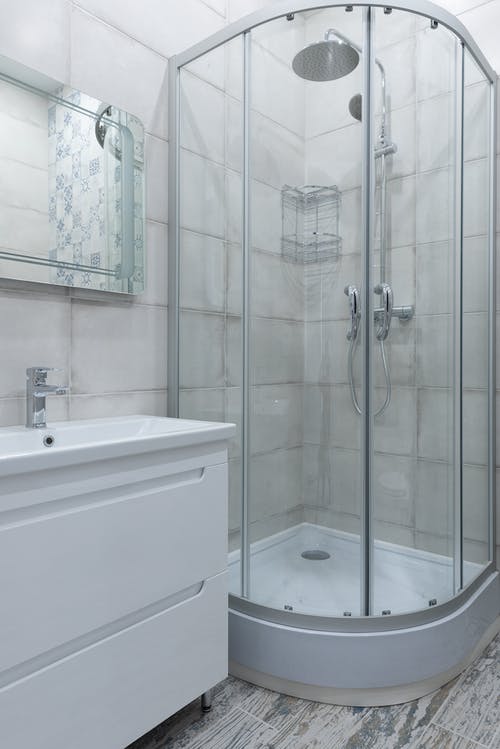 白色陶瓷浴缸，配不锈钢淋浴喷头 · 免费素材图片