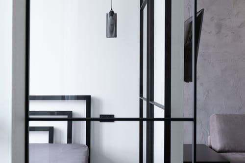 白墙旁的黑色金属框架床 · 免费素材图片