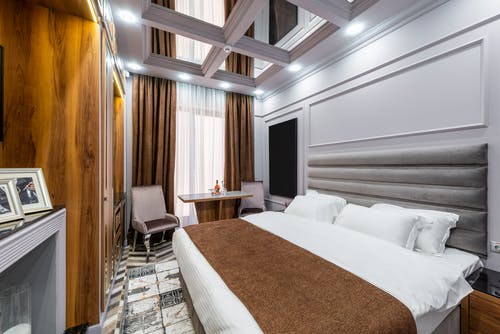 白色床单附近棕色木制床架 · 免费素材图片