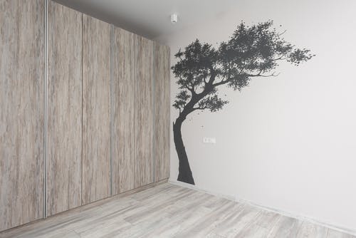 绿树附近的棕色木墙 · 免费素材图片