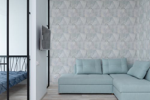 白色和蓝色墙壁旁边的灰色沙发 · 免费素材图片