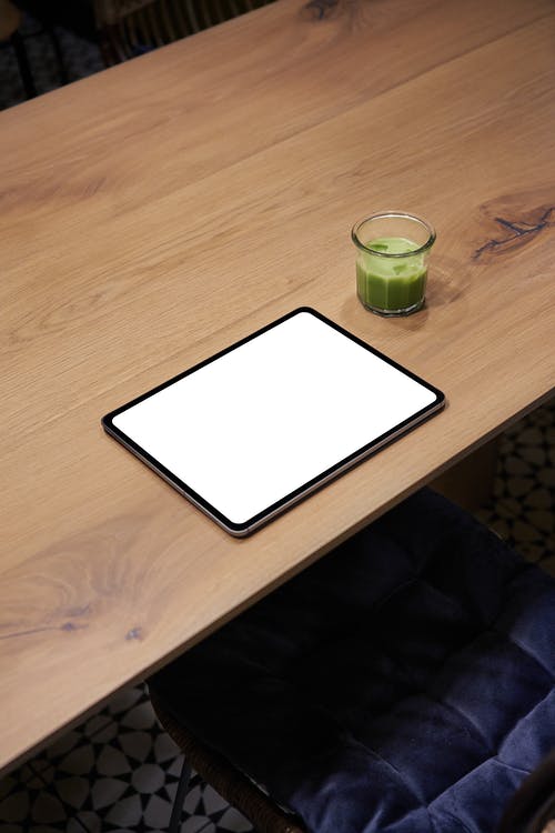 棕色木制的桌子上的白色平板电脑 · 免费素材图片