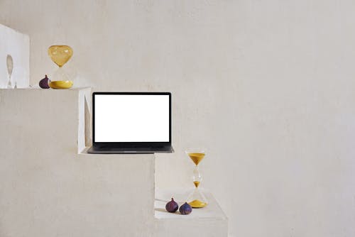 沙漏附近台阶上的笔记本电脑 · 免费素材图片