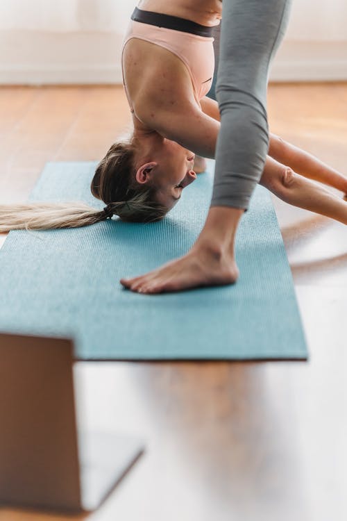 灰色背心和灰色紧身裤，躺在蓝色瑜伽垫上的女人 · 免费素材图片