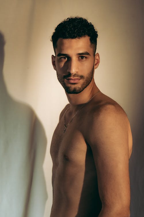 裸照的男人站在白墙附近 · 免费素材图片