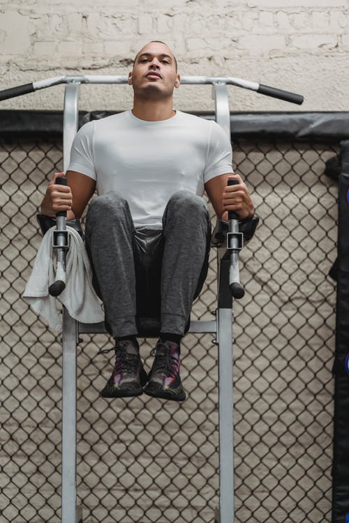 白船员的脖子t恤和黑色的裤子，坐在灰色的椅子上的女人 · 免费素材图片