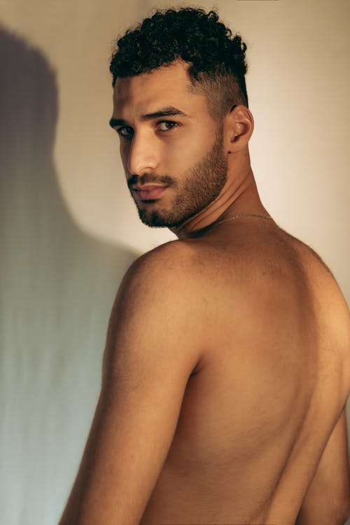 裸照的男人站在白墙附近 · 免费素材图片