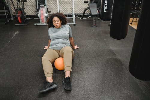 灰色背心坐在灰色地毯上的女人 · 免费素材图片