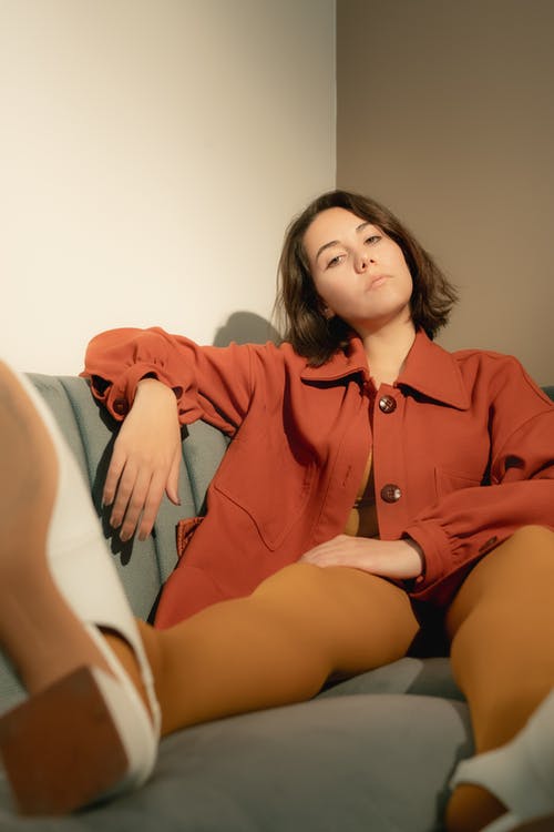 红色按钮的长袖衬衫，坐在白色沙发上的女人 · 免费素材图片