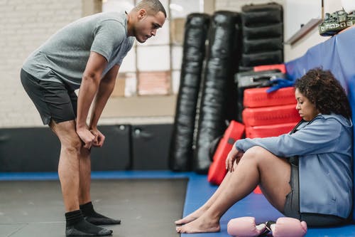 穿着灰色圆领t恤和蓝色短裤坐在蓝色瑜伽垫上的男人 · 免费素材图片