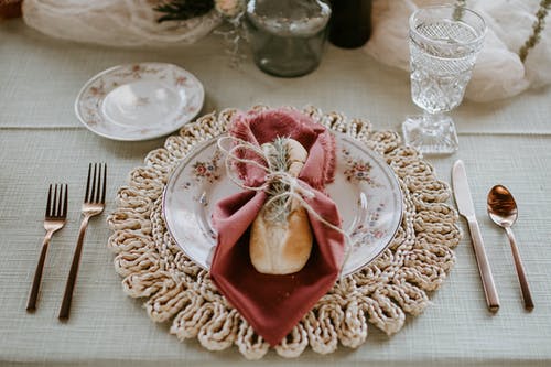 白色的桌布上的白色和红色花卉陶瓷板 · 免费素材图片