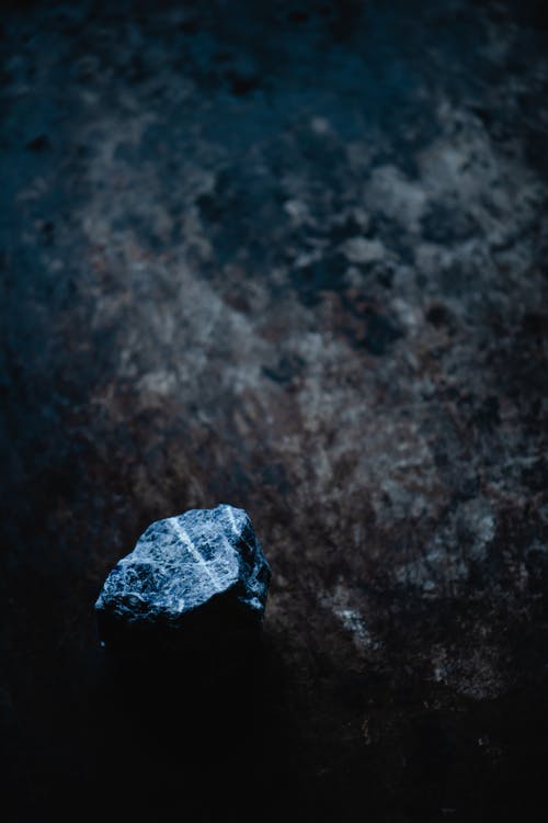 黑色表面上的灰色石头 · 免费素材图片