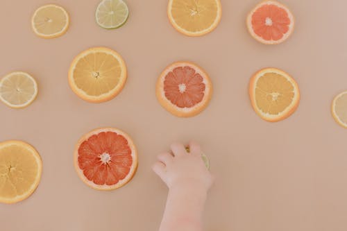 有关手, 柑橘类水果, 橙片的免费素材图片