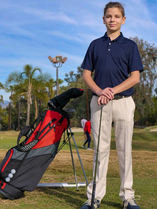 在高尔夫球场穿着蓝色衬衫的年轻高尔夫球手 · 免费素材图片