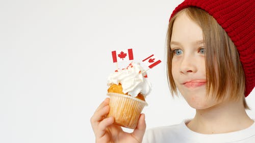 孩子拿着带有加拿大国旗的白色蛋糕 · 免费素材图片