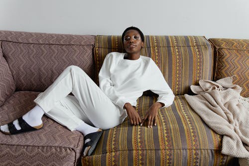 坐在白色的胸部，棕色和米色的沙发上的男人 · 免费素材图片