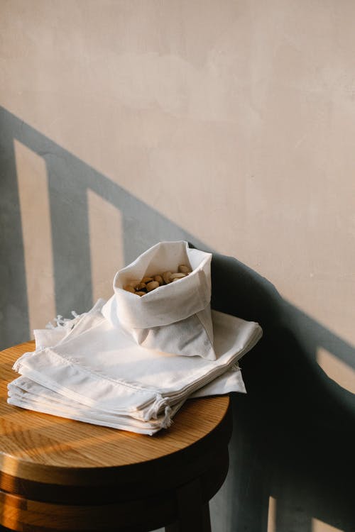 棕色木制的桌子上的白色纺织品 · 免费素材图片