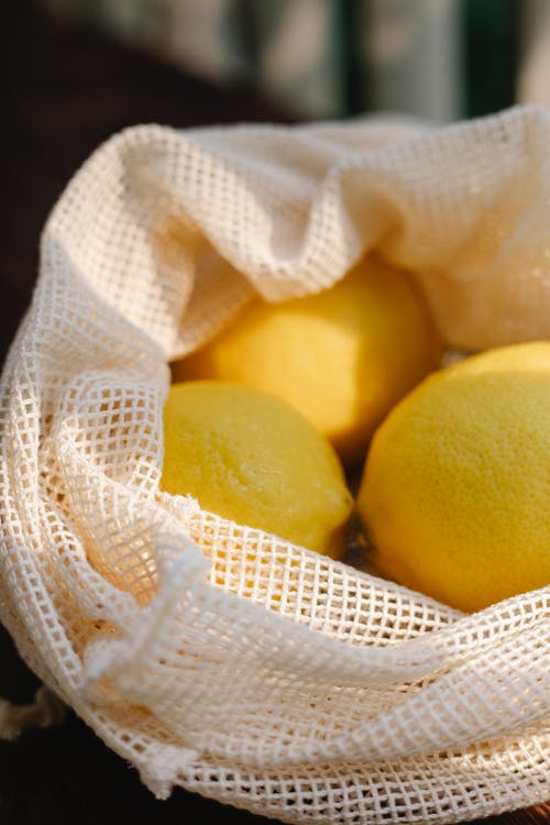 白色针织纺织品上的黄色柠檬 · 免费素材图片