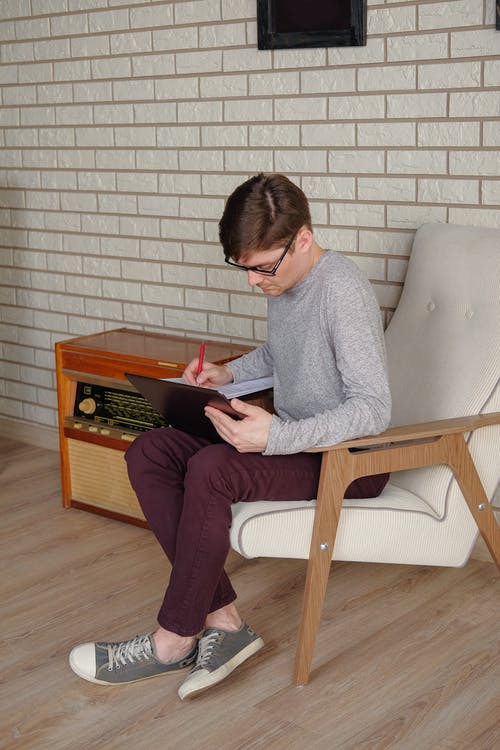 有关3C用品, 人, 单人沙发的免费素材图片