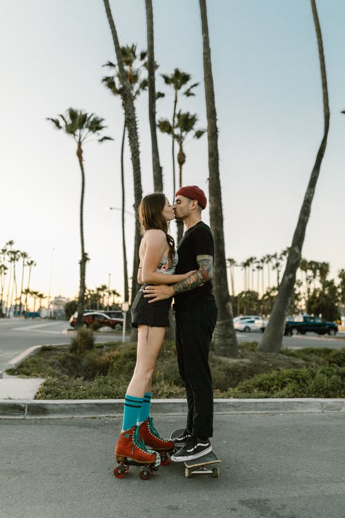 一对穿着轮滑鞋的情侣接吻 · 免费素材图片