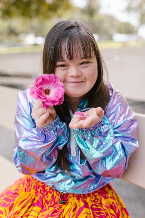 拿着桃红色花的蓝色和桃红色礼服的女孩 · 免费素材图片