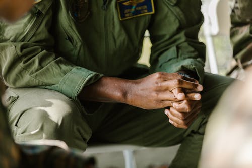 衬衫和灰色的裤子，拿着黑色的智能手机的绿色按钮的人 · 免费素材图片